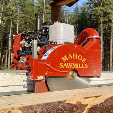 Red Mahoe Sawmills sawmill machine cutting wood outdoors.