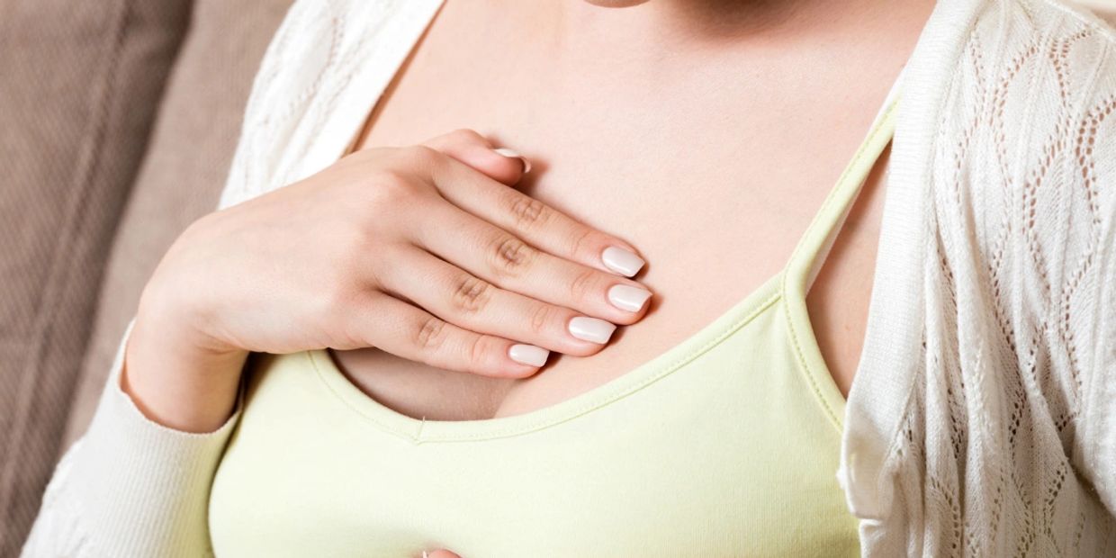 Woman placing hand on chest, showing concern or care.