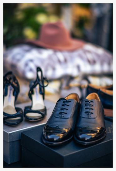 Elegant black leather shoes and high-heeled sandals displayed on boxes.