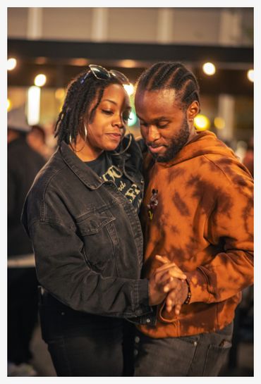 Couple sharing a tender dance moment outdoors at night.