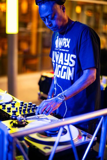 DJ performing live with intense focus on turntables and mixer.