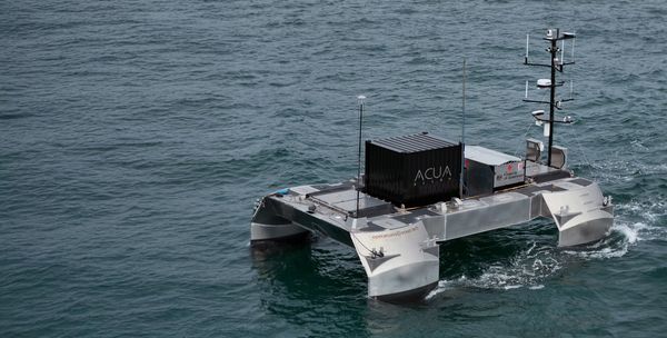 Autonomous marine vessel with antennas and sensors on water.