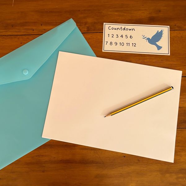 Blue envelope, blank paper, pencil, and countdown card.