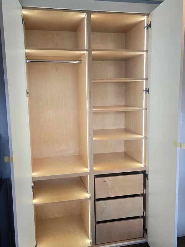 Empty wooden shelves with built-in lighting and three sliding panels.