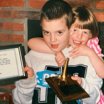 Two children holding awards, smiling and posing for a photo.