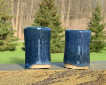 photo of blue spruce glaze dipped in cream on two different clay types