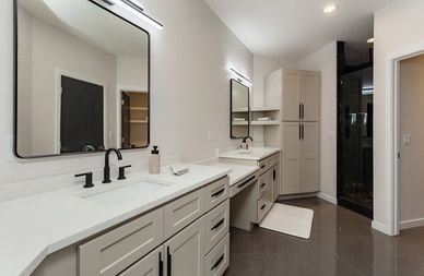 Modern bathroom with dual sinks, large mirrors, and sleek cabinetry.