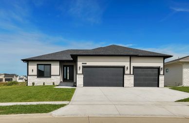 Modern single-story house with a three-car garage and black accents.