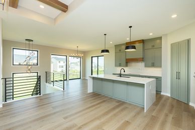 Modern open kitchen with large island and pendant lights.