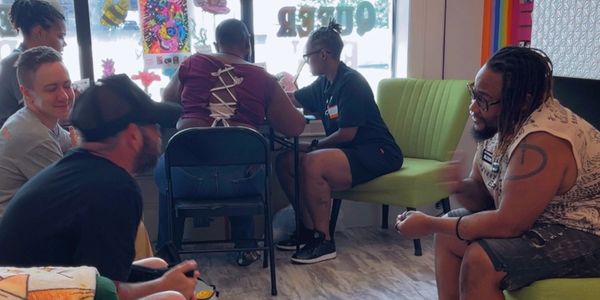 People socializing indoors, seated in small groups.