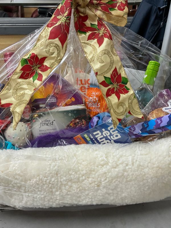 Festive gift basket with holiday ribbon and assorted treats.