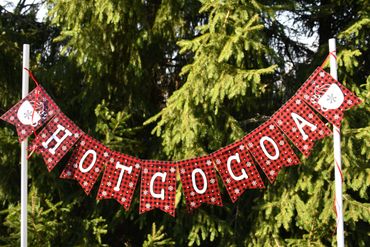 Red and black checkered banner spelling HOT COCOA with snowflakes and mugs.