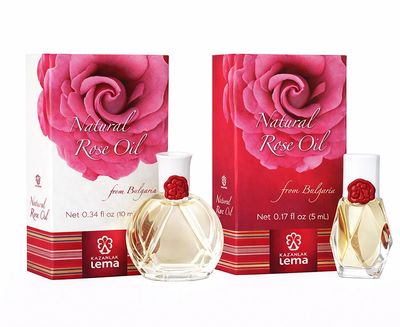 Two boxes of natural rose oil with matching glass bottles and red rose caps.