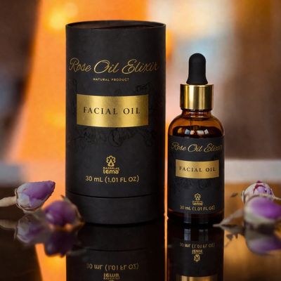 Elegant Rose Oil Elixir facial oil packaging with rosebuds around.