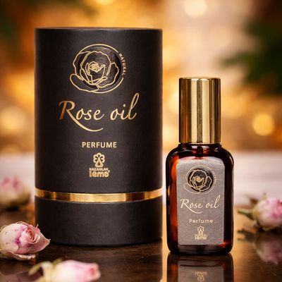 Elegant rose oil perfume bottle and packaging with gold accents.