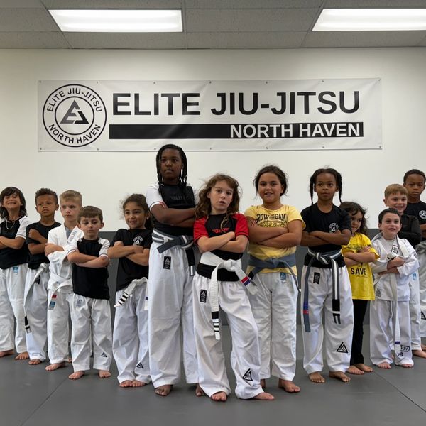 A diverse group of kids posing confidently at Elite Jiu-Jitsu North Haven.