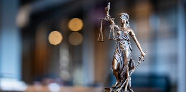 Statue of Lady Justice holding scales and sword, symbolizing fairness and law.