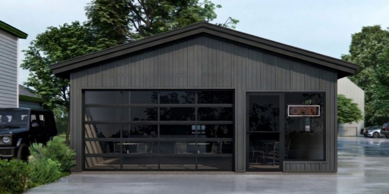 Modern black building with glass garage door and open sign on entrance.