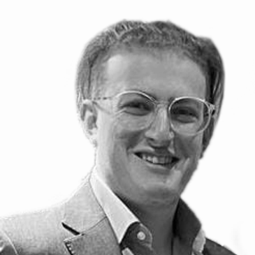 Smiling man with glasses in a suit.