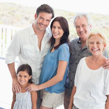 Smiling multigenerational family posing together outdoors.