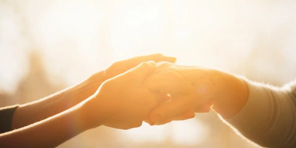 Two people holding hands warmly.