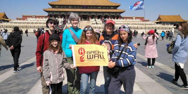Group holding Great Wall Adventure Club banner at Forbidden City.