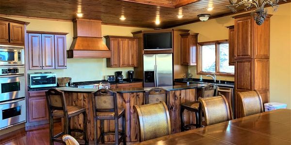 The kitchen dining room combo offers seating for 12. There is a wall of windows overlooking the lake