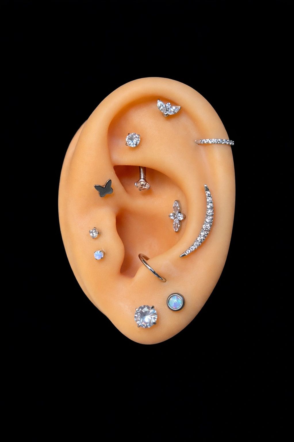 Jewelry shown on a display ear to demonstrate curated piercing styles.