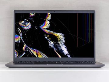 Laptop with a severely cracked and damaged screen.