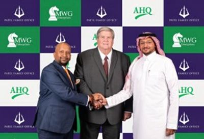 Three men shaking hands in front of a branded backdrop.