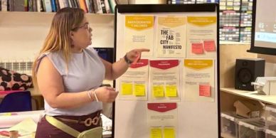 Woman explaining The Fab City Manifesto on a board.