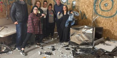 Group of people posing in a broken room.