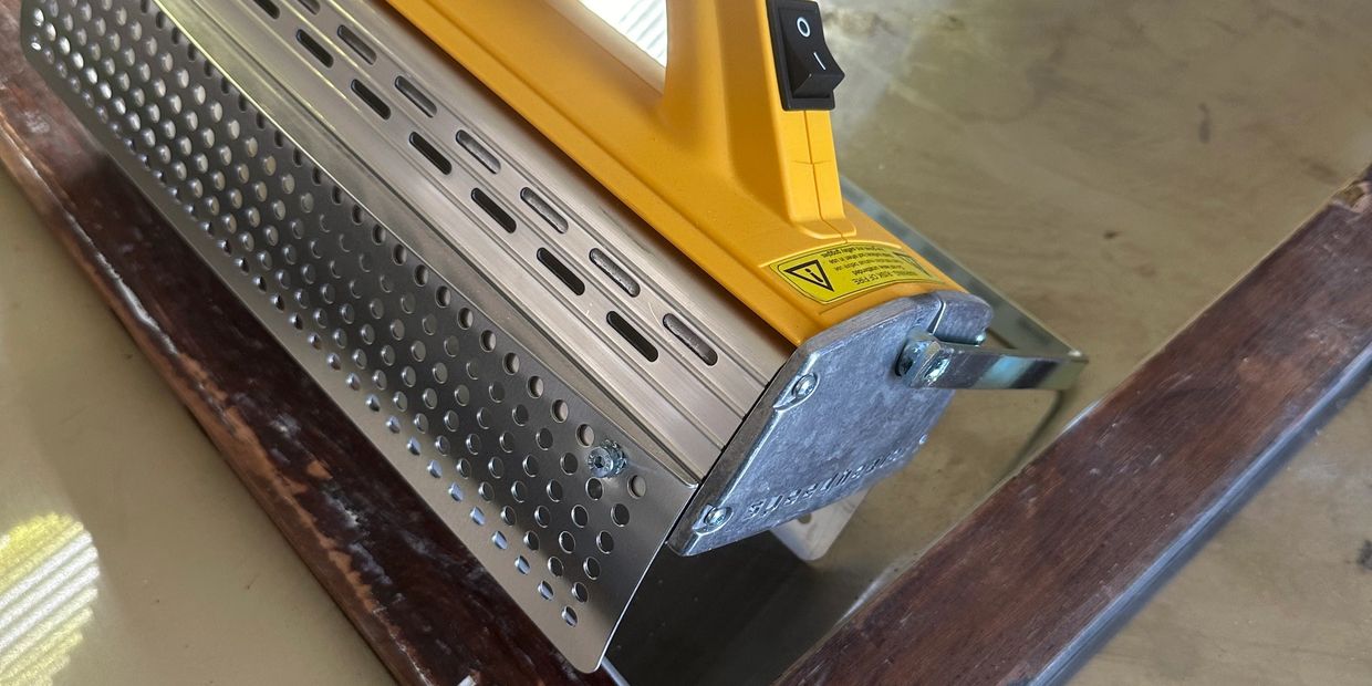 Close-up of a yellow handheld fabric heater.