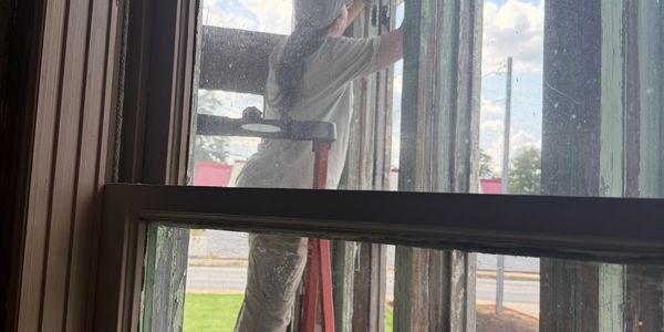 Person cleaning windows from outside with a squeegee.