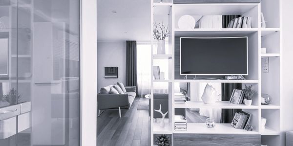 Modern living room with built-in shelving and TV.