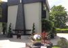 an outdoor fireplace on the patio of a renovated 1970's house in Essex