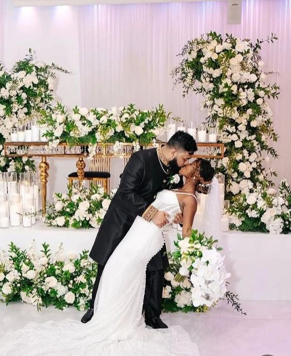 Bride and groom sharing a romantic dip kiss at their wedding.