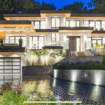 Modern luxury house with bright exterior lighting at dusk.