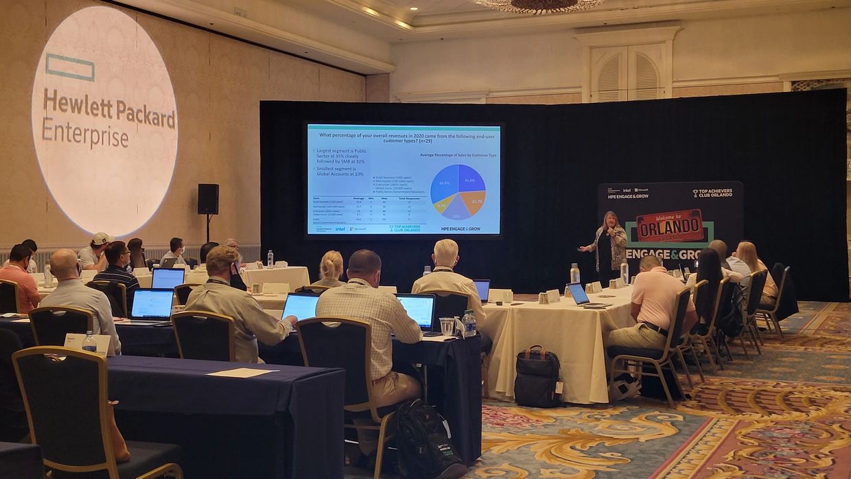 Business conference presentation with attendees and Hewlett Packard Enterprise branding.