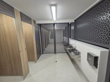 Modern public restroom with stalls and sinks.