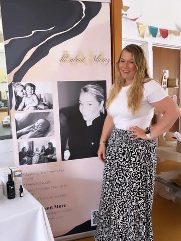 Woman standing next to a banner about skincare or treatments with photos.