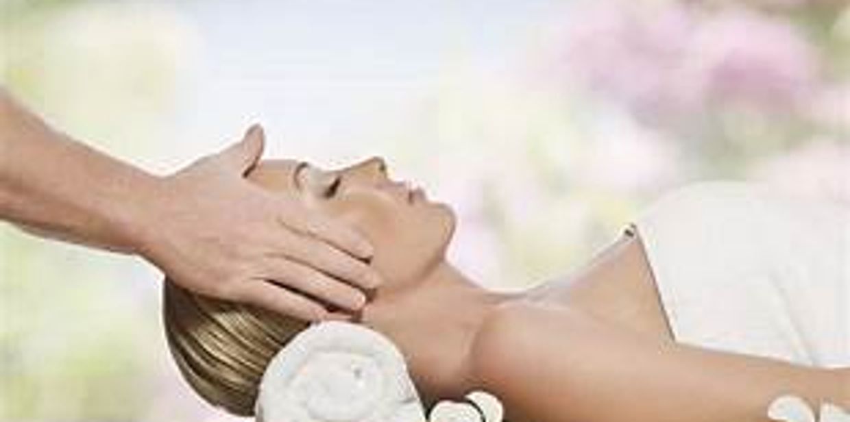 Woman receiving a relaxing head massage outdoors.