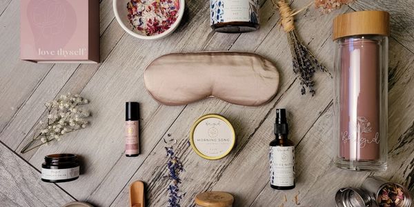 A flat lay of wellness and self-care products on a wooden surface.