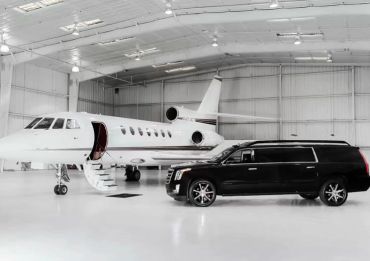 Private jet and luxury SUV in a hangar.