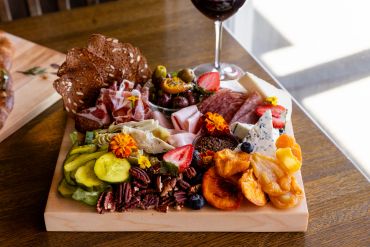 Charcuterie board with meats, cheeses, fruits, and nuts.