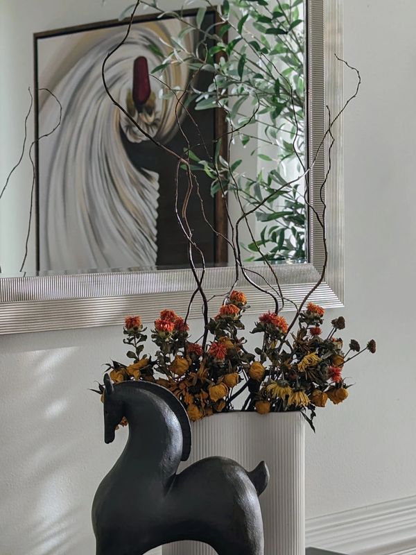 Dried flowers in a modern curved vase. 