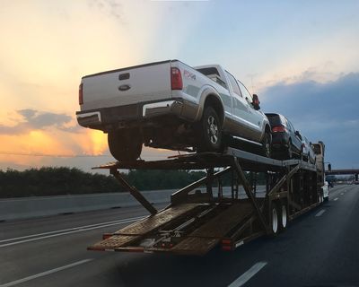 Car carrier truck with sunset in background