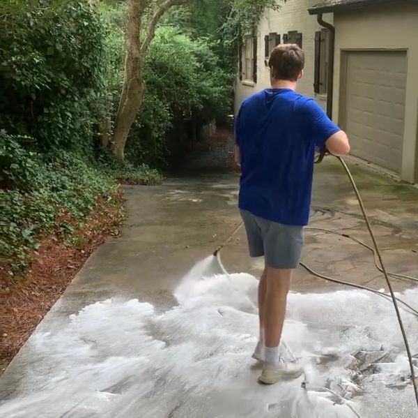 Soft-washing Service a Driveway and applying an eco-friendly solution.