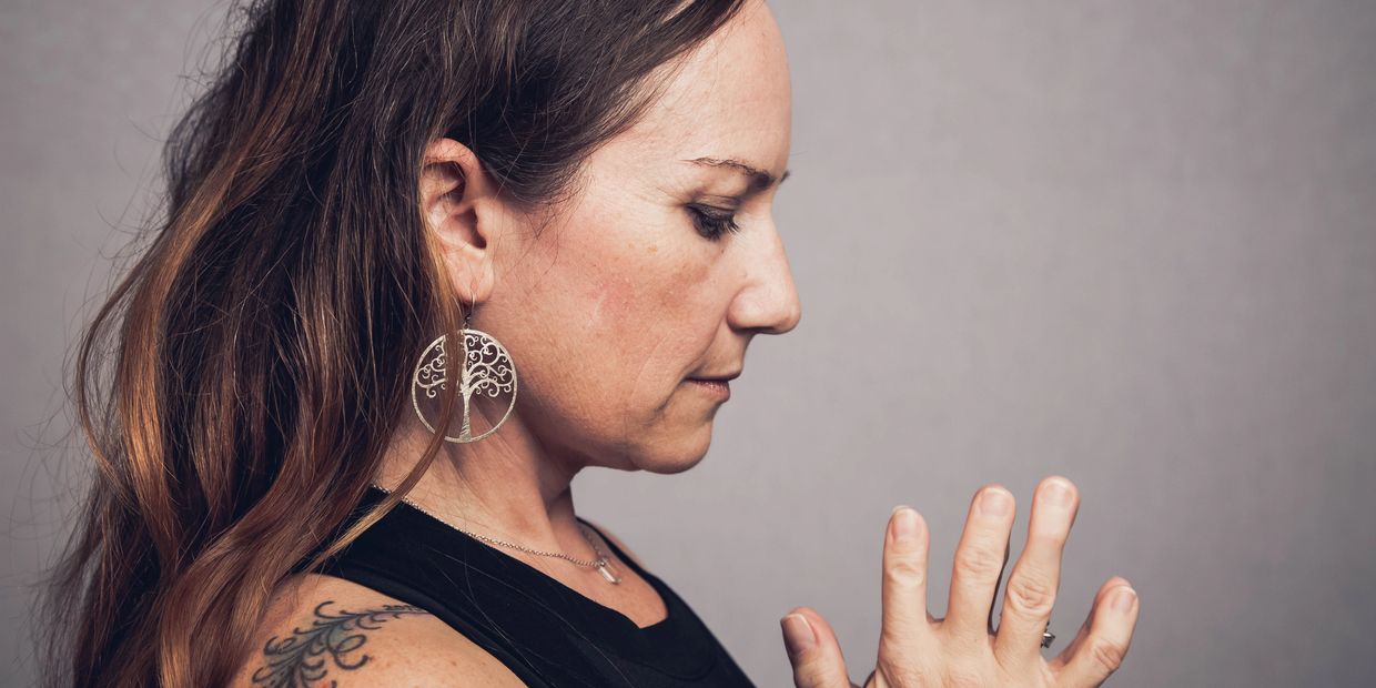 side view of a yoga teacher with hands in prayer