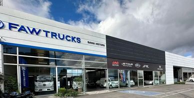 FAW Trucks dealership under a partly cloudy sky.